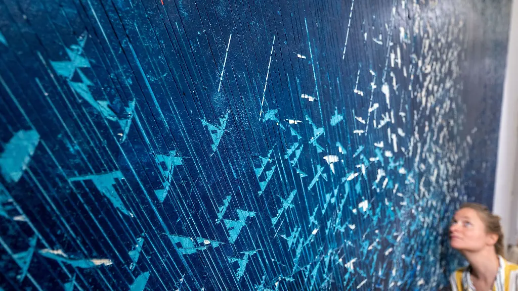 Kuenstlerin-Hanna-Sass-steht-in-der-Jahresausstellung-der-Burg-Giebichenstein-Kunsthochschule-Halle-vor-ihrer-Holzreliefarbeit-Matti-an-the-birds