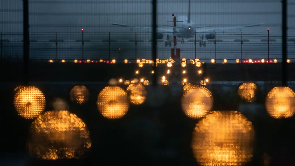 Ein-Flugzeug-landet-hinter-Signallichtern-auf-einem-Flughafen