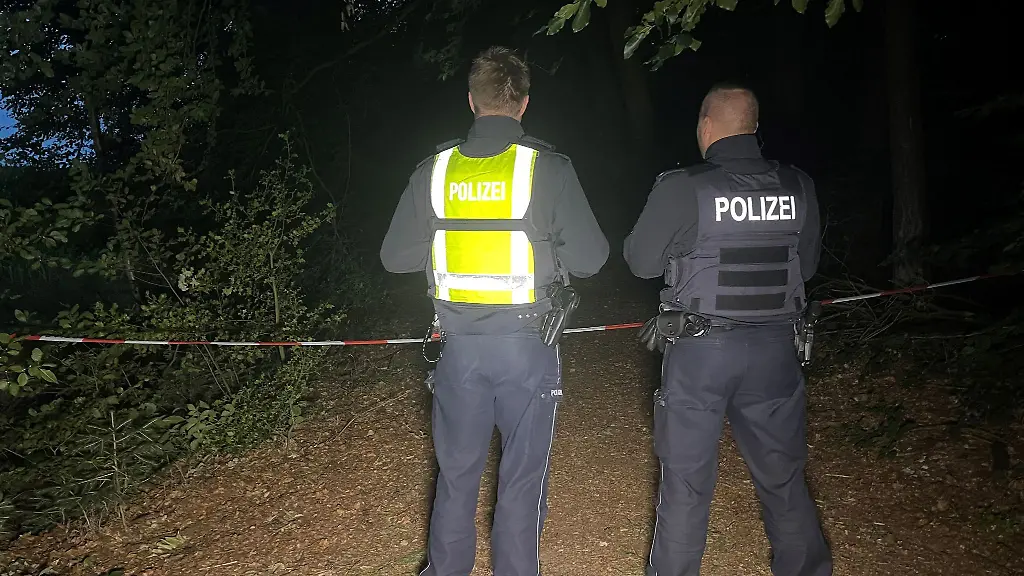 Polizisten-stehen-an-einem-abgesperrten-Waldstueck