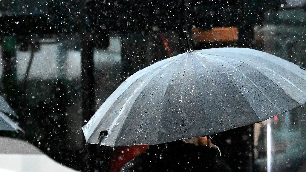 Ein-Mann-steht-bei-Regen-vor-einem-Bus