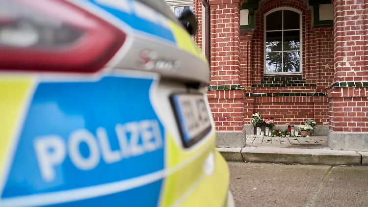 Vor dem Gebäude, in dem sich die Gewalttaten ereignet haben sollen, liegen Blumen und einige Kerzen als Zeichen der Anteilnahme. 