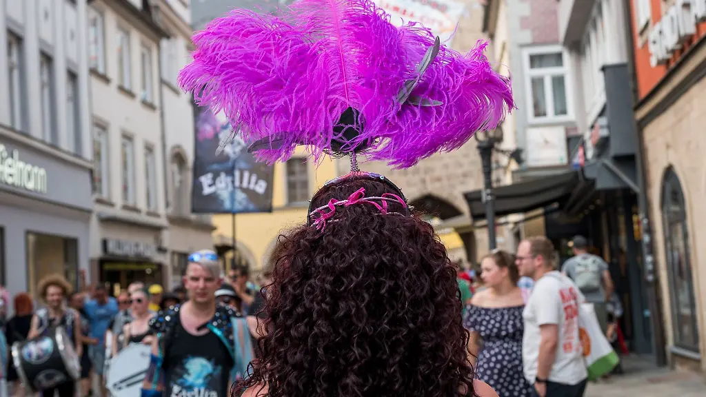 Eine-Person-mit-Federkopfschmuck-laeuft-waehrend-des-Samba-Festivals-durch-die-Innenstadt