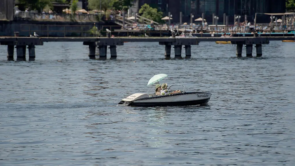Mit-doppelter-Kopfbedeckung-sind-diese-beiden-Tretbootfahrerinnen-auf-der-Spree-unterwegs