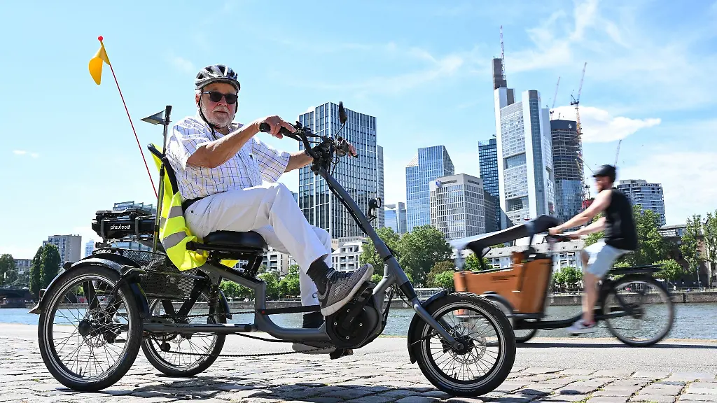 Harry-Herrmann-Hubert-Sprecher-der-AG-Mehrspurig-im-ADFC-Hessen-e-V-steht-mit-seinem-mit-Elektromotor-unterstuetzten-Dreirad-am-Mainufer