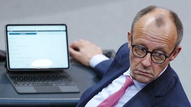 CDU-Chef Merz sitzt im Plenarsaal im Bundestag.