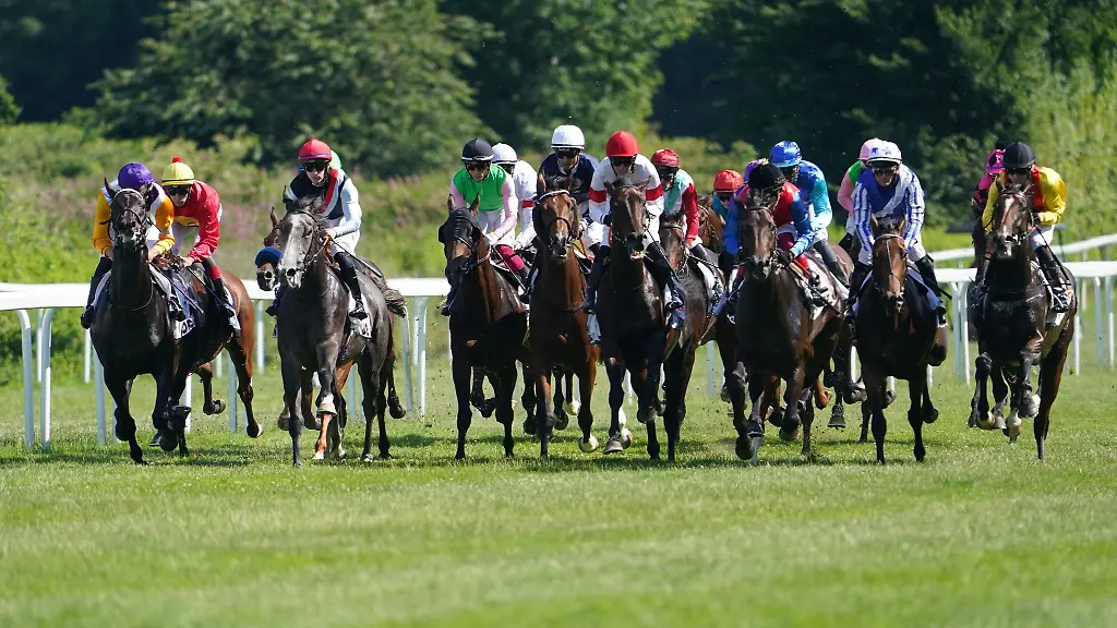Die-Teilnehmer-des-Deutschen-Derbys-laufen-an-der-Tribuene-vorbei