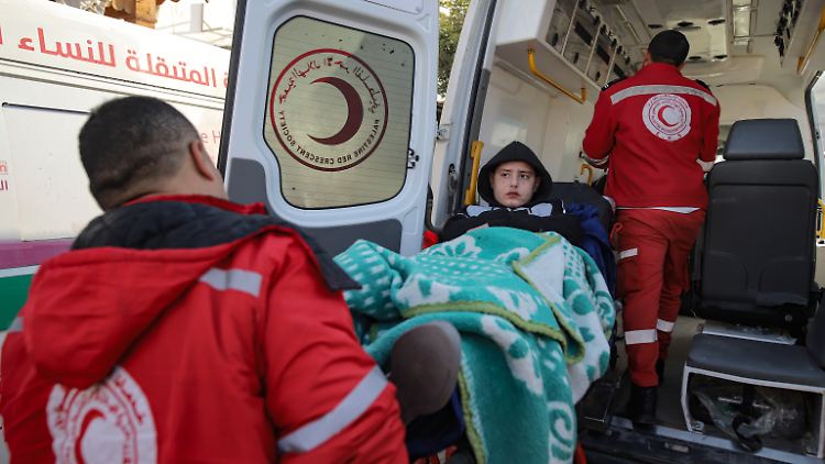 Ein palästinensisches Mädchen, das bei der israelischen Bombardierung verwundet wurde, wird von Sanitätern getragen, bevor es die Grenze nach Ägypten überquert. 