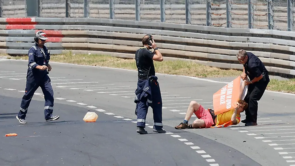 Streckenposten-zerren-einen-Aktivisten-der-Letzten-Generation-am-9-7-2023-mit-Protestbanner-in-der-Hand-von-der-Fahrbahn