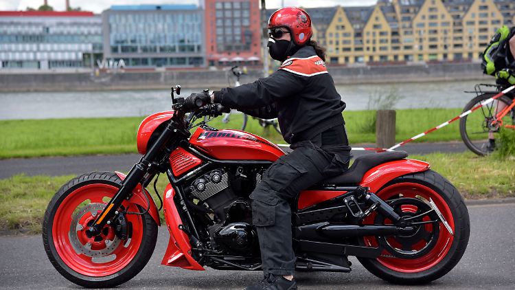 Ein Fahrer und seine Harley-Davidson-Maschine am Rhein in Köln.