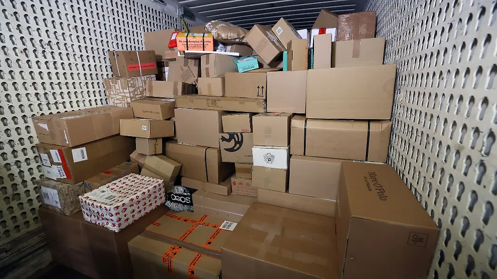 In-einer-Zustellbasis-liefert-ein-LKW-Pakete-an-um-sie-auf-die-Zustellfahrzeuge-aufzuteilen