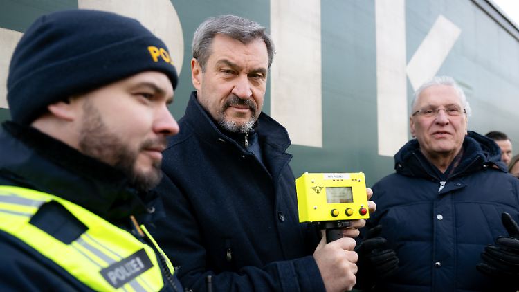 Söder nimmt zusammen mit Bayern Innenminister Herrmann (r.) am Grenzübergang Oberaudorf an einer Kontrolle eines Lkw teil. Söder hält dabei einen Herzschlagdetektor in den Händen.