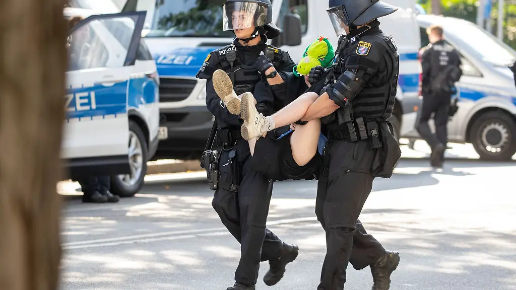 Polizisten-tragen-einen-Besetzer-vom-Gelaende