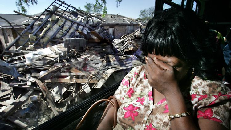 Eine Frau hält sich die Augen zu, als sie zwei Monate nach dem Wirbelsturm "Katrina" zum ersten Mal seit der Zerstörung durch ihr Viertel im Lower 9th Ward in New Orleans fährt.