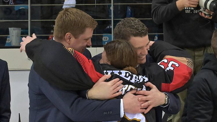 Abstreiter und Trainer MacLeod (r.) umarmen sich nach der geglückten Qualifikation für die Olympischen Winterspiele 2026.