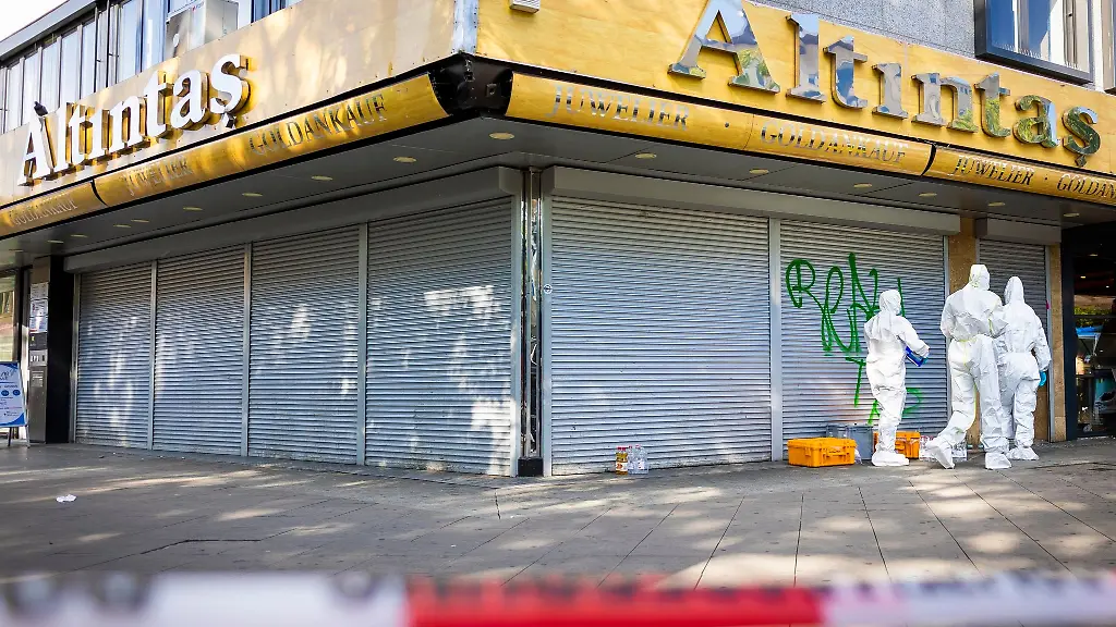 Mitarbeiter-der-Spurensicherung-stehen-vor-dem-Juwelier-in-der-Innenstadt