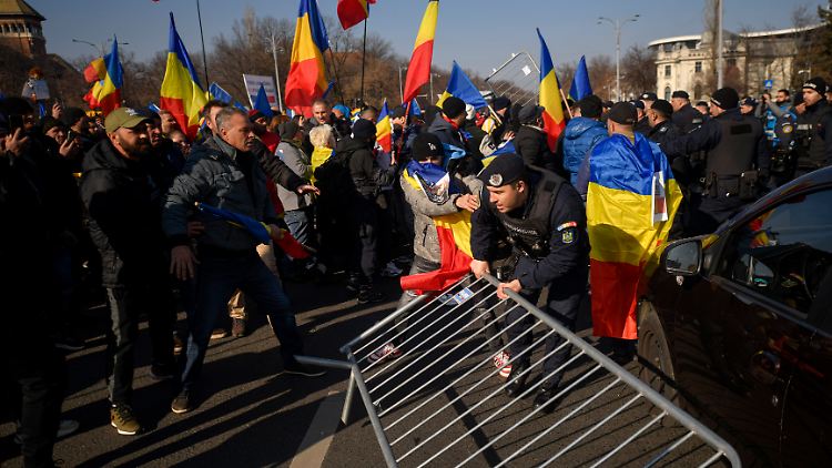 Anhänger des Gegenkandidaten Georgescu protestieren vor dem Regierungssitz.