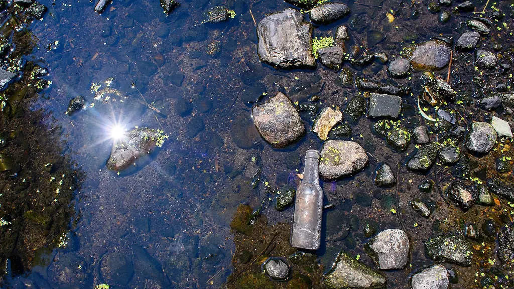 Die-Sonne-spiegelt-sich-in-einem-fast-voellig-ausgetrockneten-Fluss