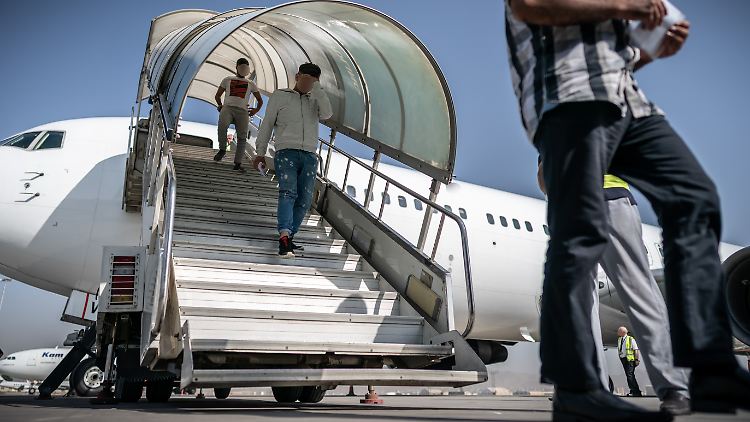 Aus Deutschland mit einem Sonderflug abgeschobene Afghanen gehen über die Gangway aus einem Charterflugzeug in Kabul.