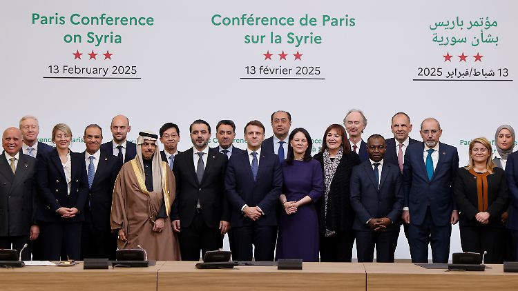 Die internationalen Teilnehmer der Syrien-Konferenz. Seite an Seite stehen Frankreichs Präsident Macron (m) und Syriens Außenminister al-Shaibani (l). 
