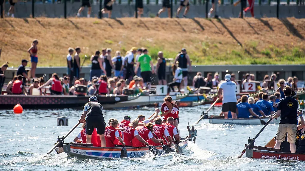 Drachenboote-fahren-im-Wettkampf-auf-dem-Altem-Strom-in-Warnemuende-zum-25-Drachenbootfestival-im-Seebad