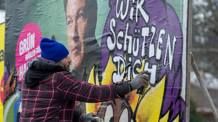 Der Künstler Bernd Imminger sprüht im Auftrag der Grünen auf ein Wahlplakat von Kanzlerkandidat Robert Habeck.