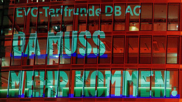 Die Forderung "Da muss mehr kommen" der Eisenbahn- und Verkehrsgewerkschaft (EVG) wird auf die Fassade eines Bürogebäudes neben dem Bahntower am Potsdamer Platz projiziert. 