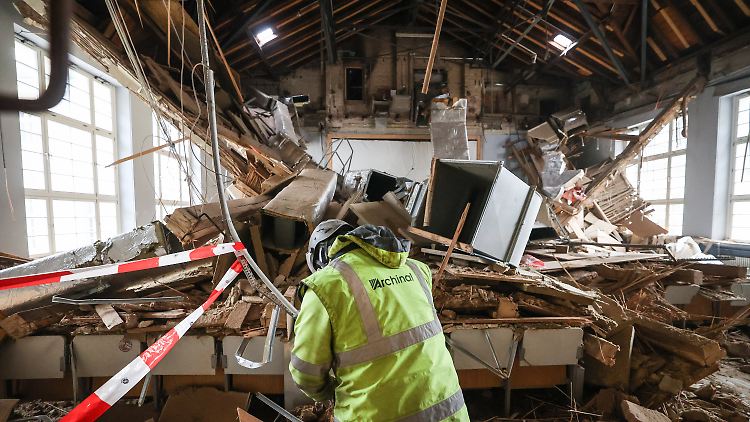 Mitarbeiter einer Spezialfirma räumen Schutt in dem zerstörten Uni-Hörsaal an der Philipps-Universität Marburg auf. In der Nacht zum 3. Dezember 2023 war die Holz-Kassettendecke eingestürzt.