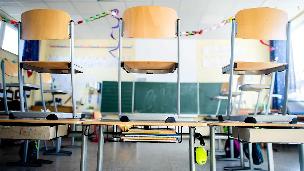 Stuehle-stehen-nach-Schulschluss-auf-den-Tischen-in-einem-Unterrichtsraum-einer-Grundschule