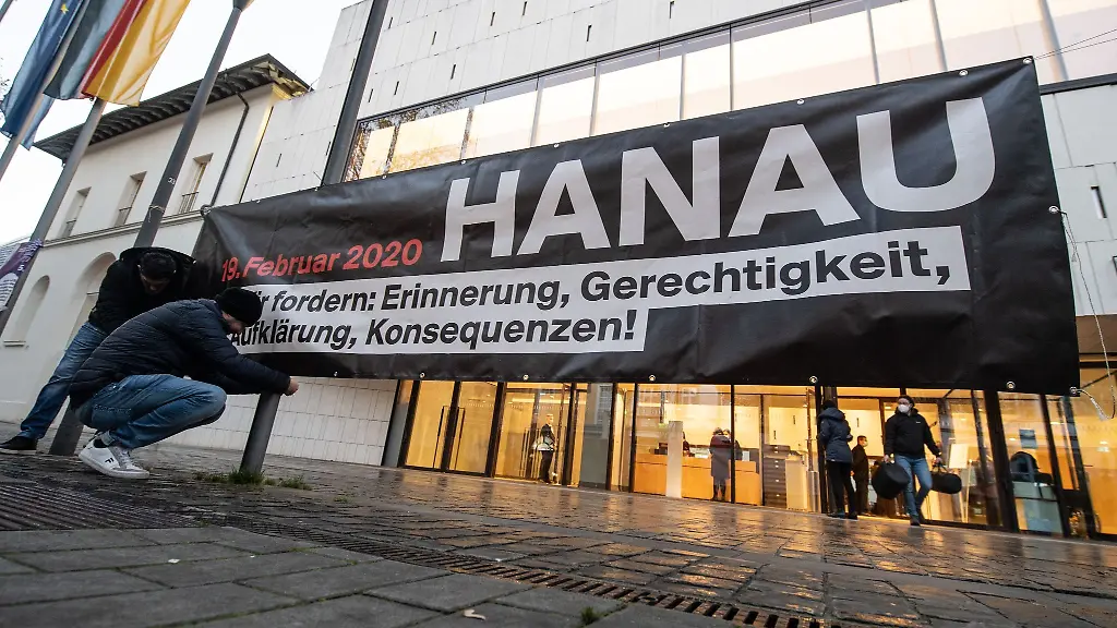 Ein-Mann-befestigt-am-20-12-2001-vor-dem-Landtag-in-Wiesbaden-ein-Banner-mit-der-Aufschrift-Hanau-Wir-fordern-Erinnerung-Gerechtigkeit-Aufklaerung-Konsequenzen