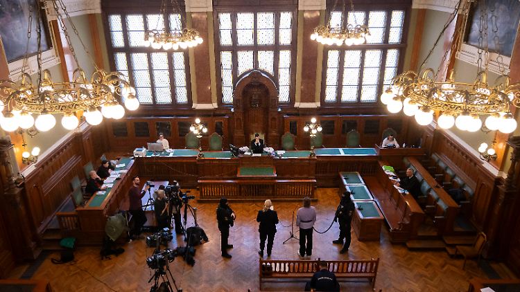 Mit gefesselten Händen und an einer Art Leine wird Maja T. zu Prozessbeginn in den Saal geführt.