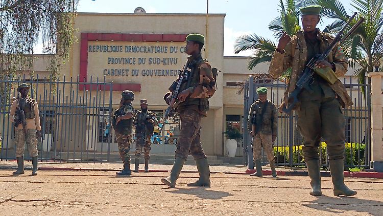M23-Rebellen patroullieren vor einem Verwaltungsgebäude der Provinz Süd-Kivu, die sie kürzlich übernommen hatten.