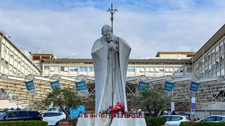 Papst Franziskus wird in der Gemelli-Klinik in Rom behandelt, davor wacht eine Statue von einem seiner Vorgänger, Papst Johannes Paul II.