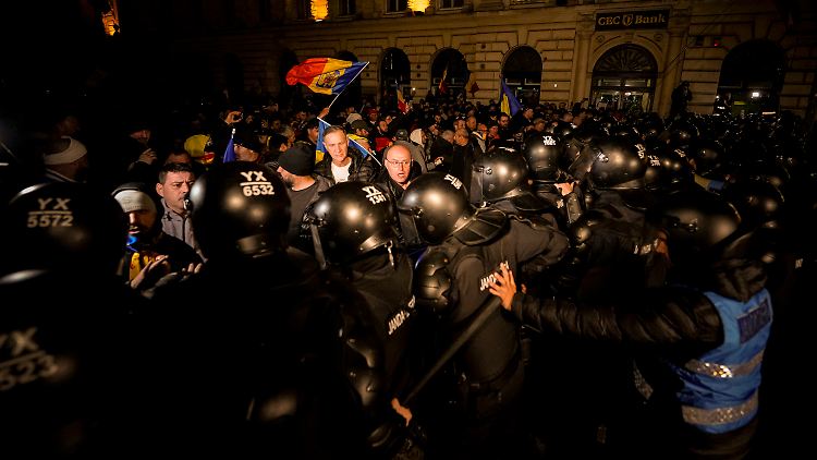 Polizisten versuchen, die protestierenden Anhänger von Calin Georgescu zurückzudrängen.