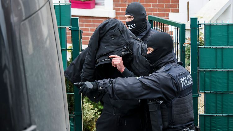 Ein Verdächtiger wird von der Bundespolizei aus seinem Objekt eskortiert.