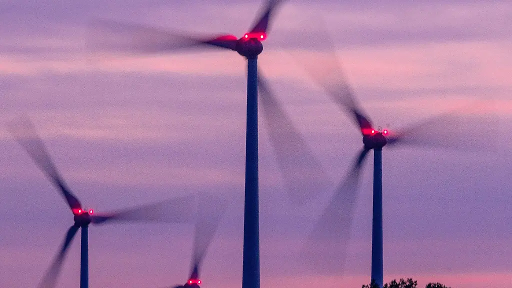Mit-Signallampen-beleuchtete-Windraeder-drehen-sich-nach-Sonnenuntergang