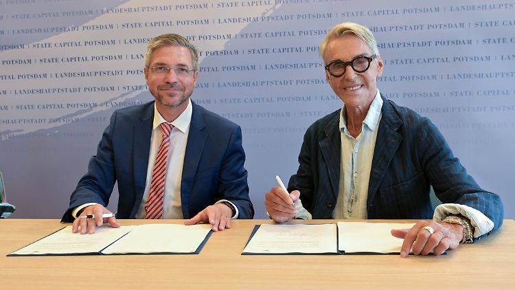 Hier ist die Vorfreude noch groß: Potsdams Oberbürgermeister Mike Schubert und Modedesigner Wolfgang Joop unterzeichnen im August 2023 im Rathaus Potsdam ein Dokument für die geplante Ausstellung.