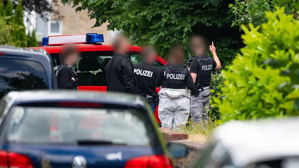 Polizeibeamte-und-Ermittler-der-Spurensicherung-untersuchen-den-Tatort