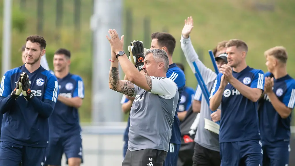 Trainer-Thomas-Reis-fuehrt-sein-Team-auf-den-Platz-und-applaudiert-den-Fans