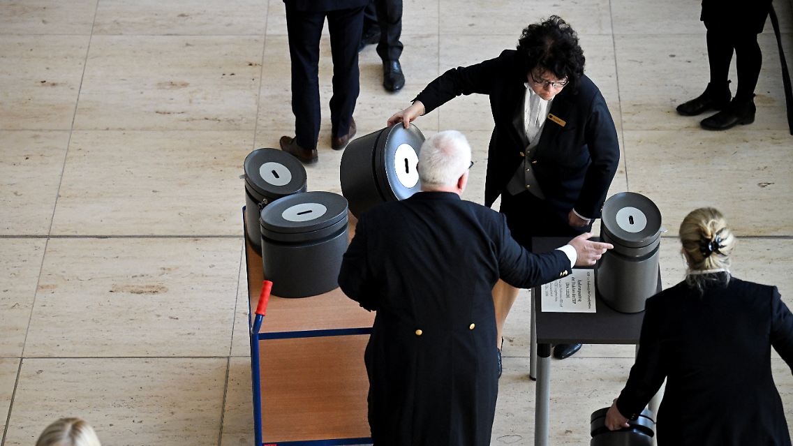 Mitarbeiter des Bundestags stellen im Foyer die Abstimmungsurnen auf.