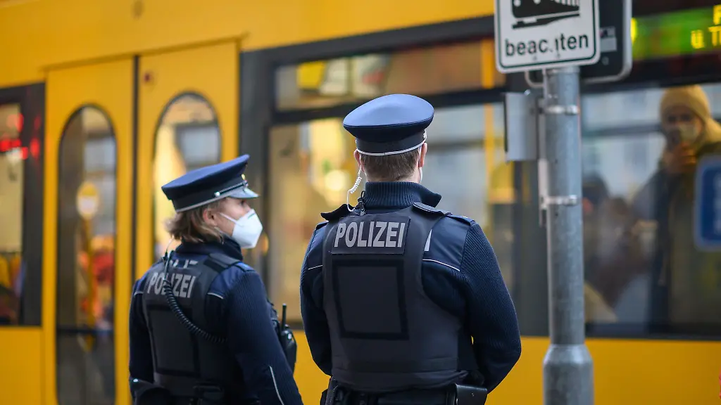 Polizisten-stehen-in-der-Dresdner-Innenstadt-an-einer-Strassenbahn-Haltestelle-der-DVB