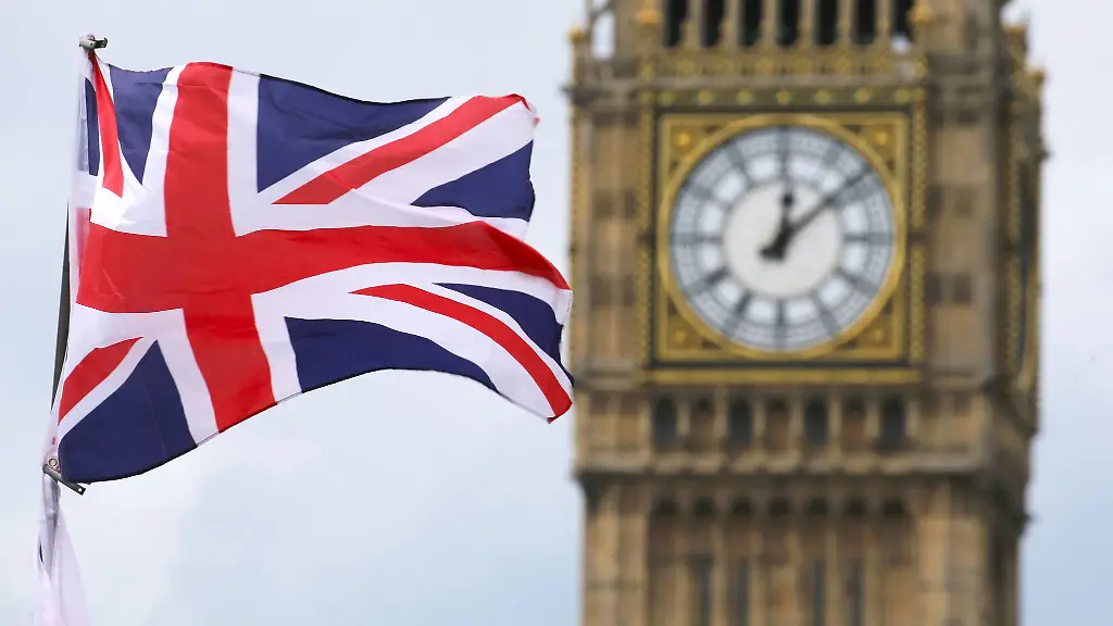 Eine-Britische-Fahne-weht-vor-dem-beruehmten-Uhrenturm-Big-Ben-in-London