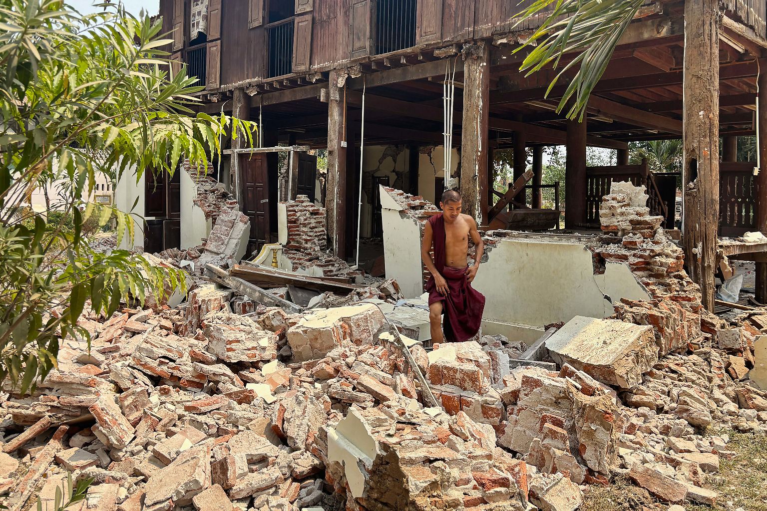 In Naypyitaw in Myanmar steht ein buddhistischer Mönch in den Trümmern einer beschädigten Klosteranlage.