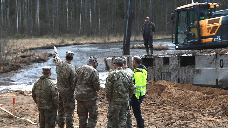US-Soldaten und litauische Armee- und Rettungsdienstmitarbeiter besprechen ihren Plan zur Bergung des Panzers. 