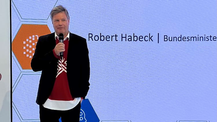 Das Eishockey-Trikot bekommt Habeck von den Kanadiern geschenkt und zieht es gleich an.