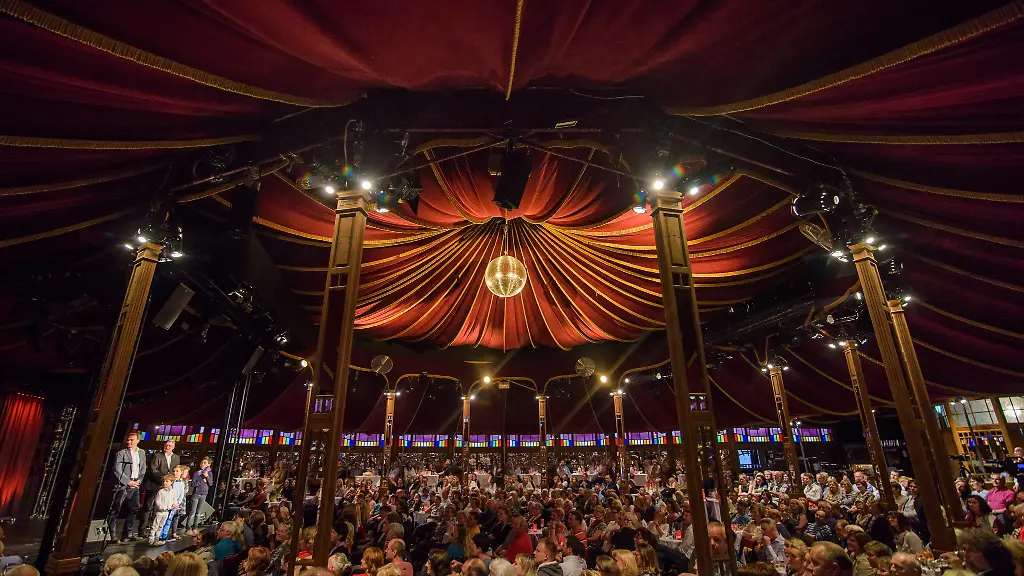 Zuschauer-sitzen-waehrend-des-Auftakts-zum-Musik-und-Kabarett-Festival-im-Spiegelzelt