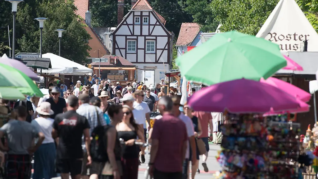 Besucher-des-Elbhangfests-gehen-an-Verkaufsstaenden-entlang