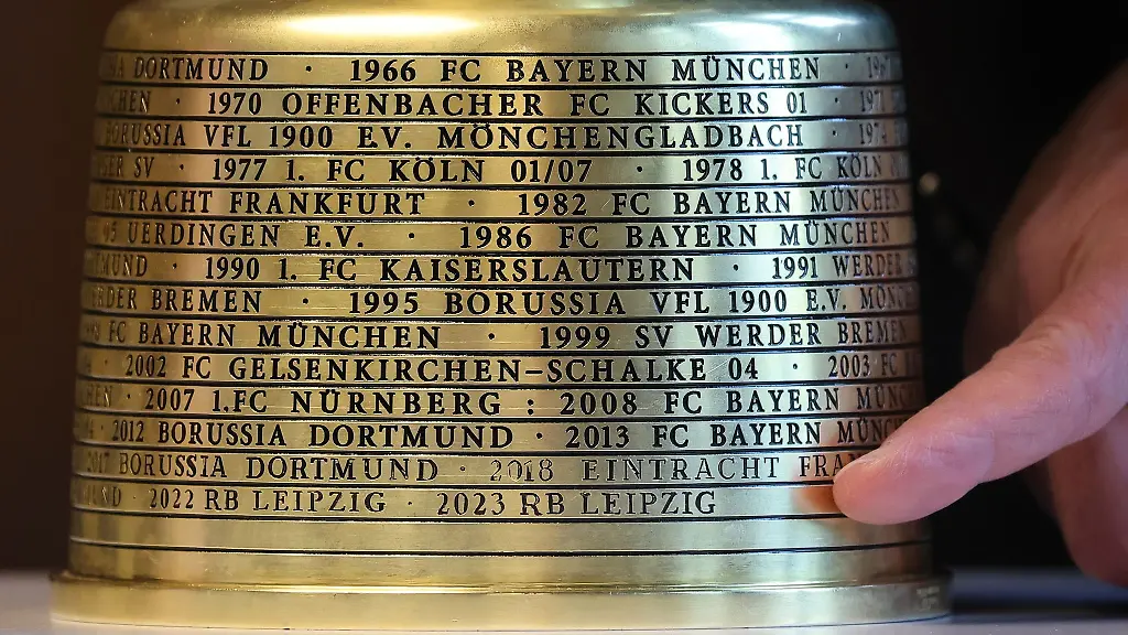 Ein-Finger-zeigt-auf-die-Gravur-2023-RB-Leipzig-am-Fuss-des-DFB-Pokals-bei-einem-Empfang-im-Neuen-Rathaus