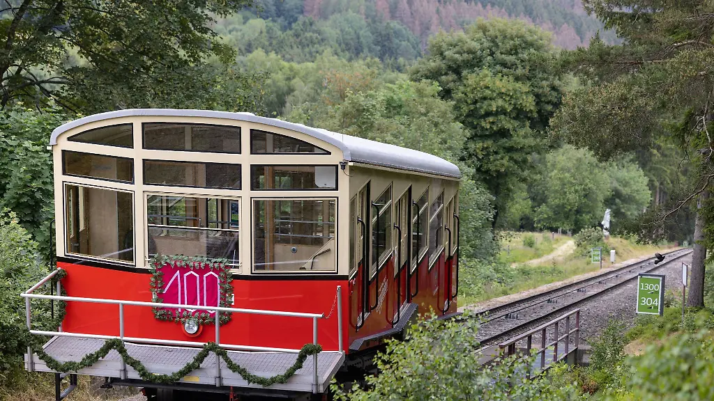 Der-geschmueckte-Personenwaggon-ist-vor-Beginn-des-Jubilaeumsfests-100-Jahre-Bergbahn-Oberweissbach-auf-der-Steilstrecke-unterwegs