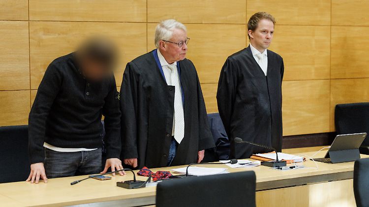 Der Angeklagte mit seinen Anwälten im Gerichtssaal. 