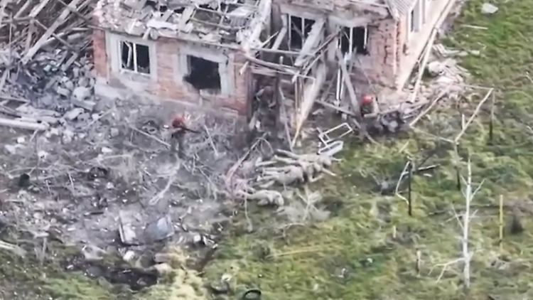 Dieses Bild aus einem Video zeigt drei Soldaten mit roten Helmen und russischen Uniformkennzeichnungen, die vier auf dem Boden liegende ukrainische Soldaten umringen. Nach Angaben europäischer Militärs wurde die Szene von einer ukrainischen Drohne in Pjatychatky am 13. März gefilmt.